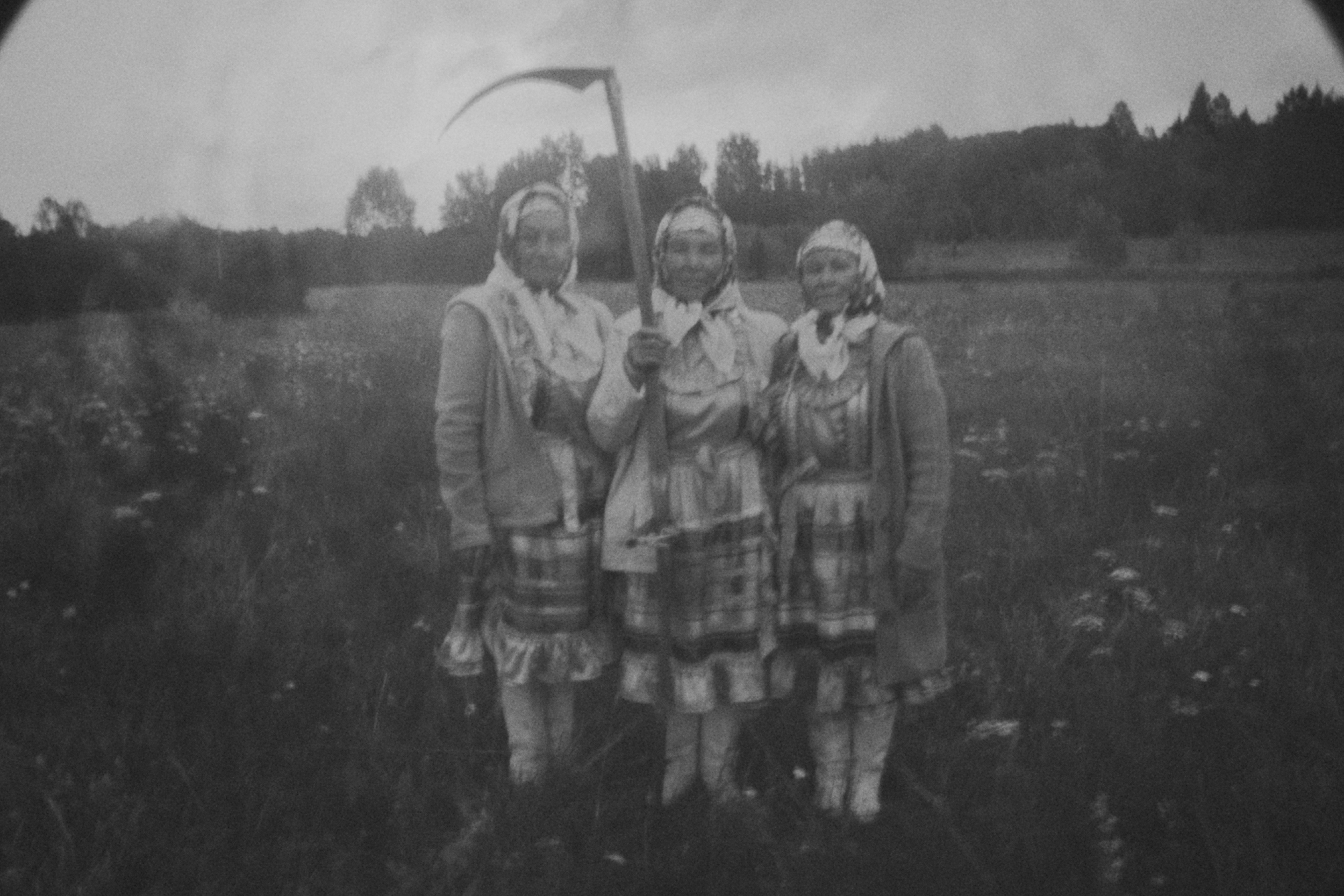 Этнографическая чёрно-белая фотография трёх женщин с косой в русском поле