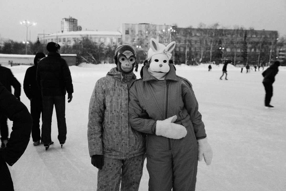 Чёрно-белая арт-фотография девушек в костюмах животных на катке, город зимой