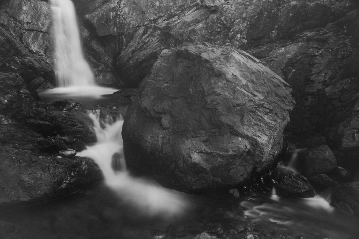 Чёрно-белая художественная фотография горного водопада и валуна, природа, пейзаж