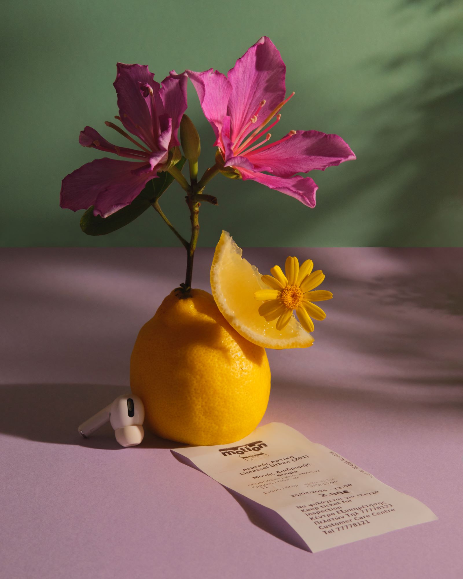 Лимон с цветами, чеком и наушником AirPods. Современная концептуальная фотография от Fainberg