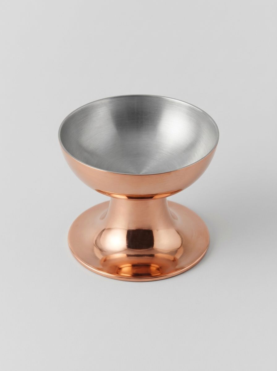 Небольшая медная креманка с широкой чашей и устойчивым основанием на светлом фоне